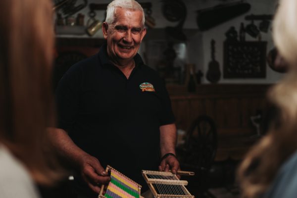 Colin Winter with a handheld weaving loom at Dan Winter's Cottage