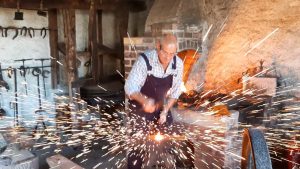 Blacksmith working on iron, with sparks