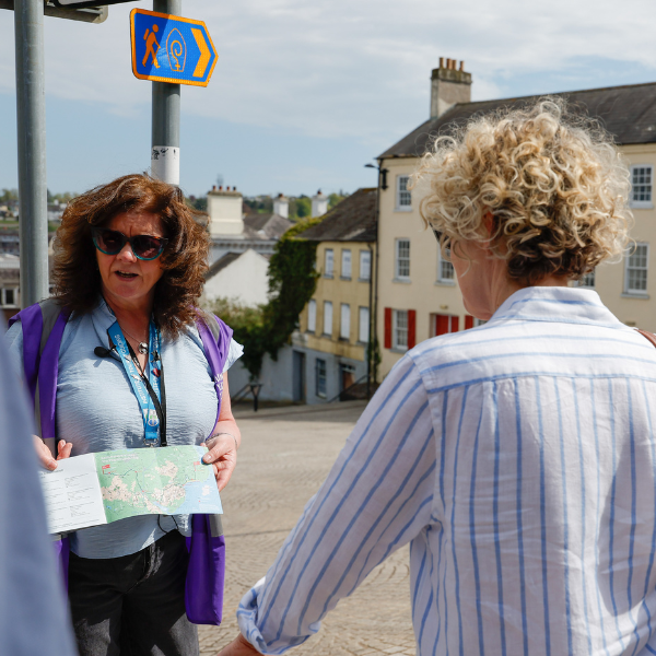 Person holding a map while leading a guided walking tour in Armagh city centre.