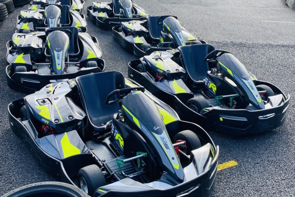 Line up of black and green racing karts on track.