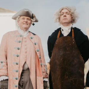 Two performers in Georgian-era costume portraying an 18th-century surgeon and assistant during a historical living history experience at the Armagh Georgian Festival.