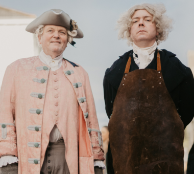 Two performers in Georgian-era costume portraying an 18th-century surgeon and assistant during a historical living history experience at the Armagh Georgian Festival.