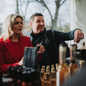 Visitors browsing artisan food and drink products at a festive market stall during the Armagh Georgian Festival.