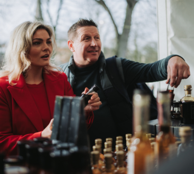 Visitors browsing artisan food and drink products at a festive market stall during the Armagh Georgian Festival.