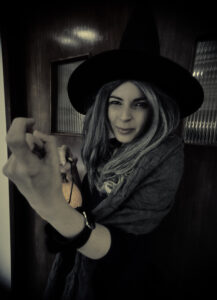 Person in a witch costume holding a lantern during Halloween Family Fun at Armagh County Museum.